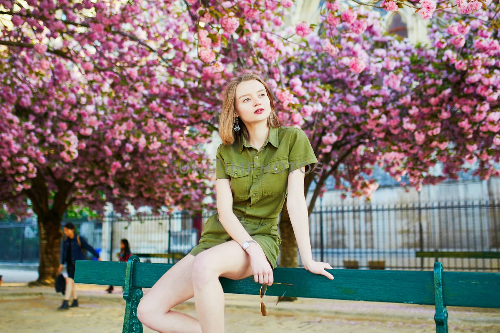 Beautiful French woman walking in Paris on a spring day at cherry blossom season