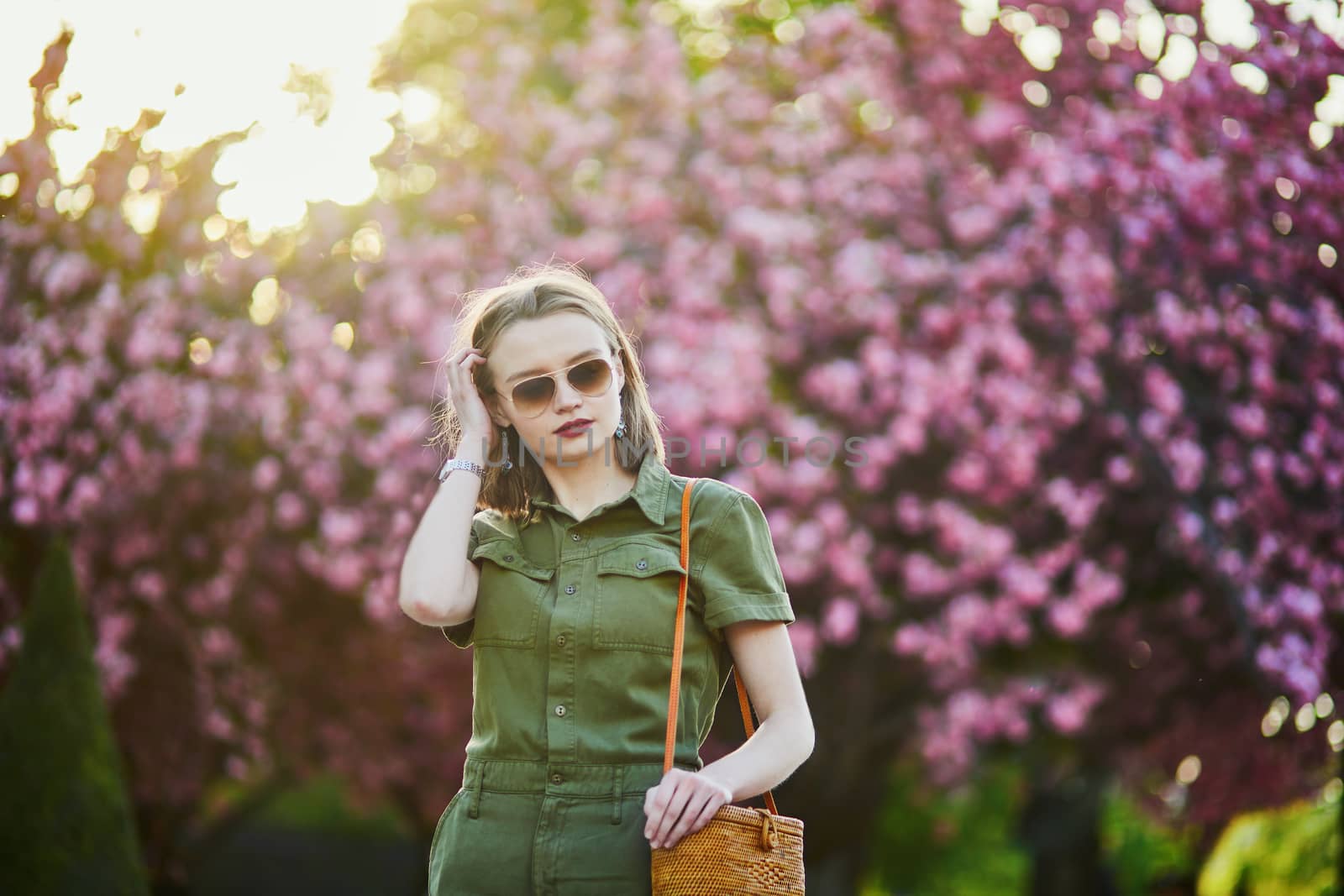 Beautiful French woman walking in Paris on a spring day at cherry blossom season