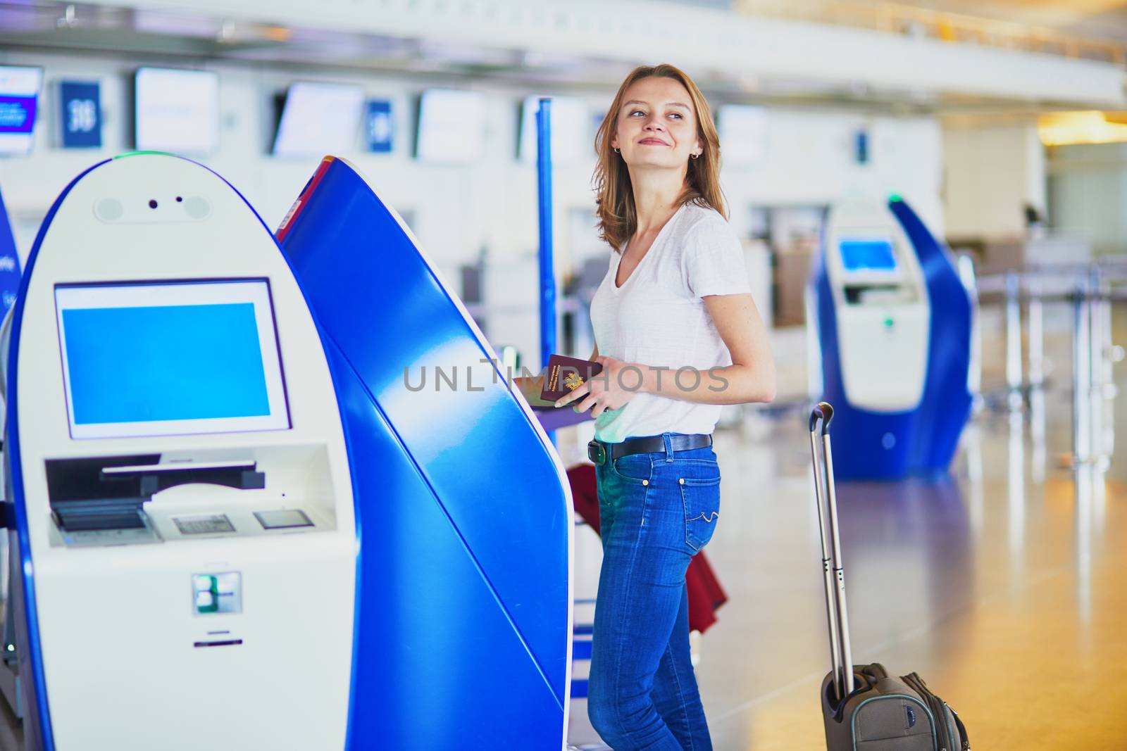 Young woman in international airport doing self check-in