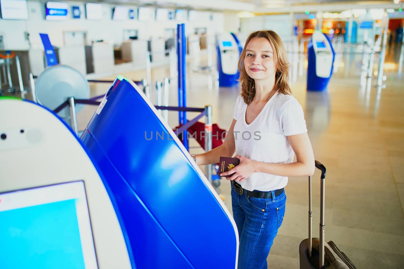 Young woman in international airport doing self check-in