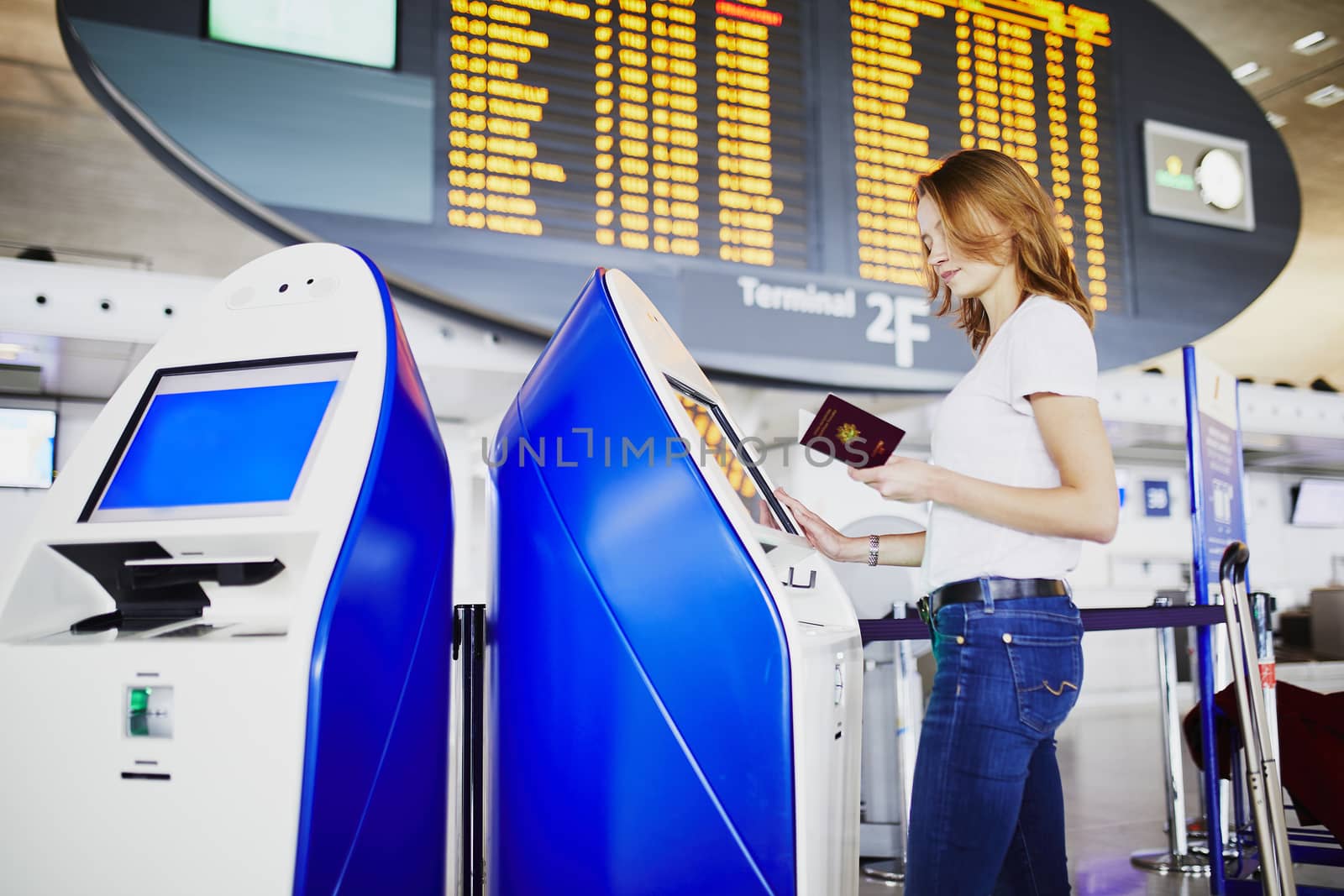 Young woman in international airport doing self check-in