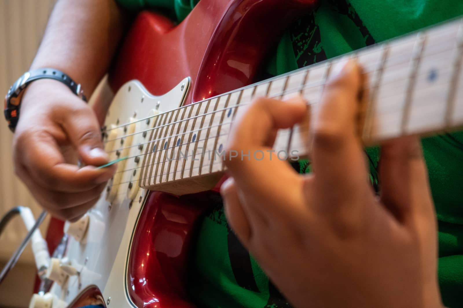 A young child playing an electric guitar