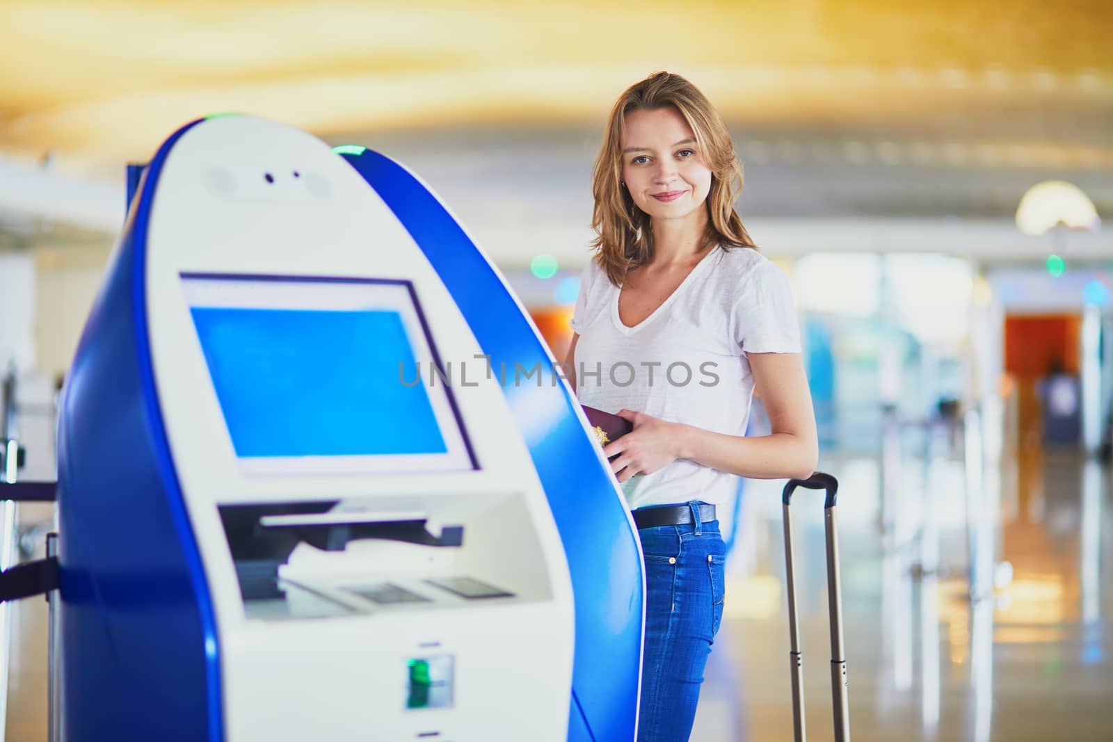 Young woman in international airport doing self check-in