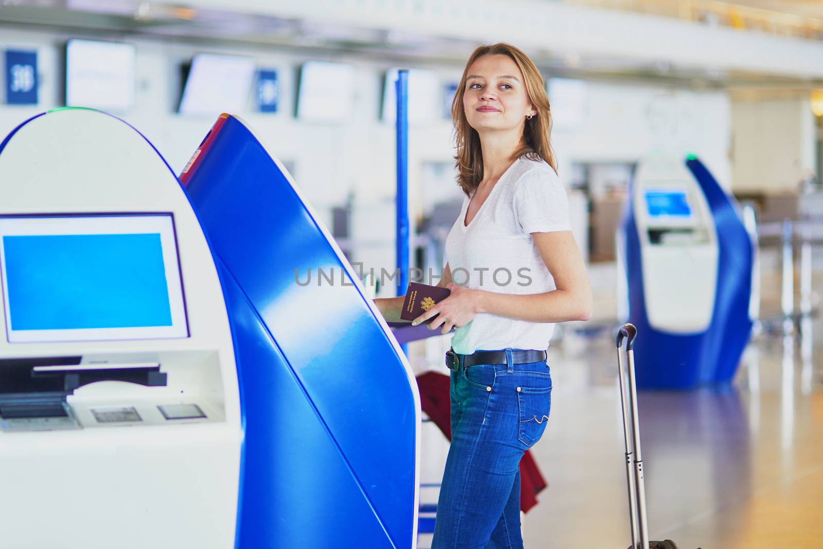 Young woman in international airport doing self check-in