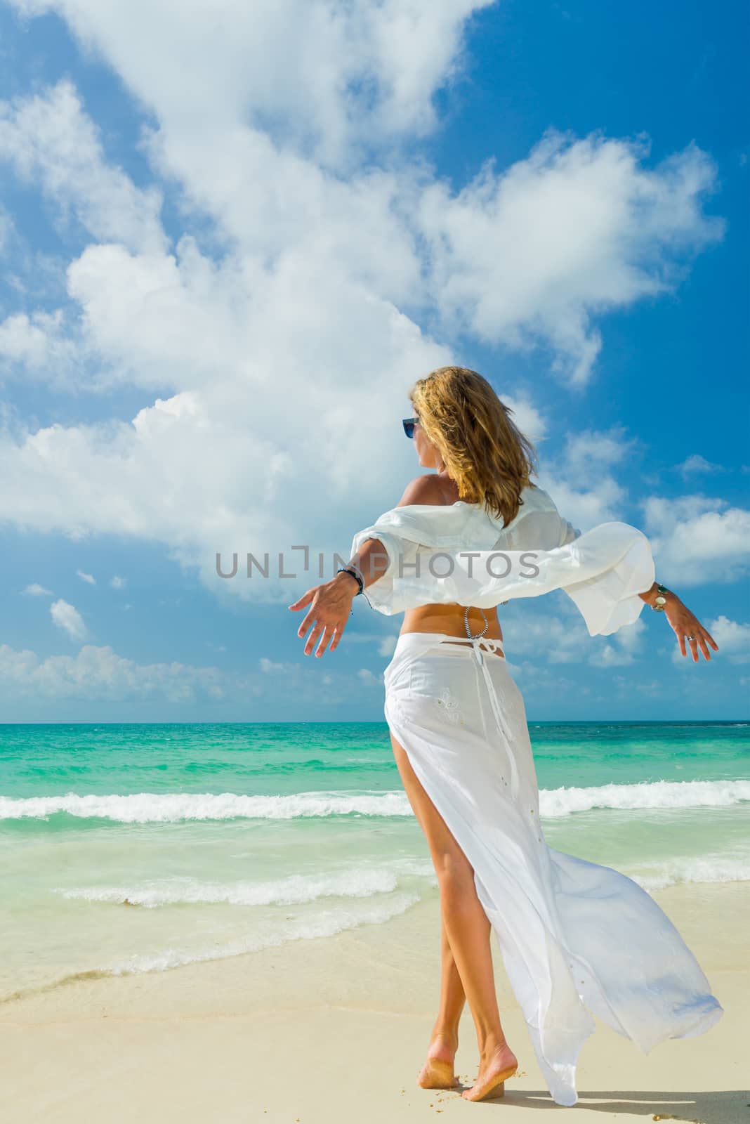 Woman walking on the beach by Netfalls