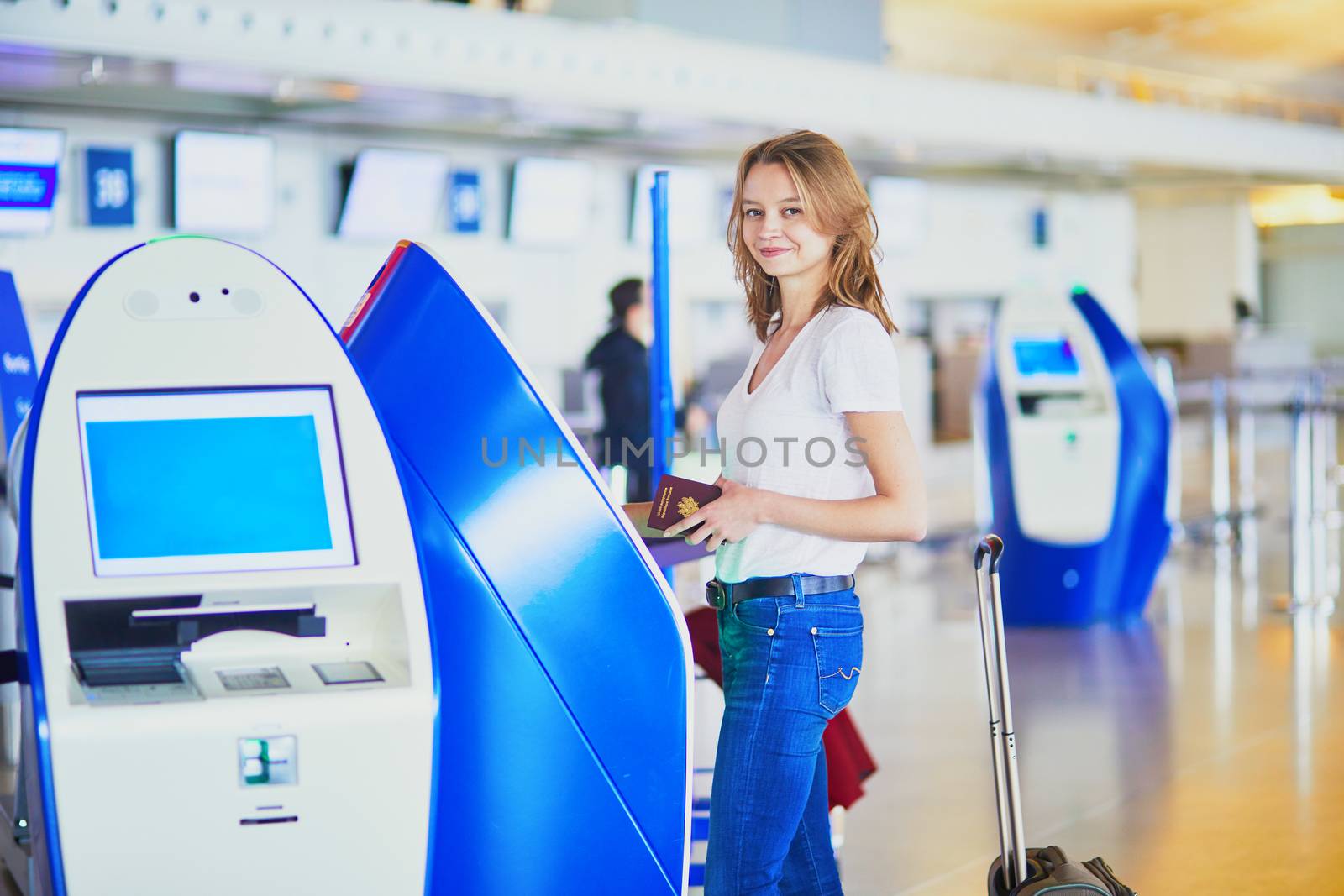 Young woman in international airport doing self check-in