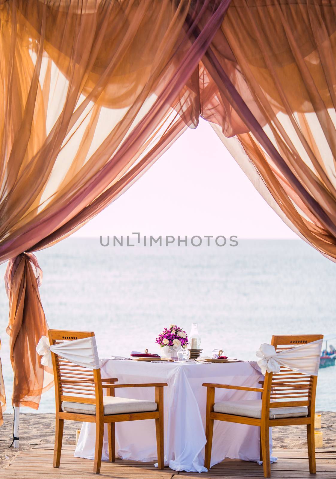 Romantic dinner setting on the beach by Netfalls