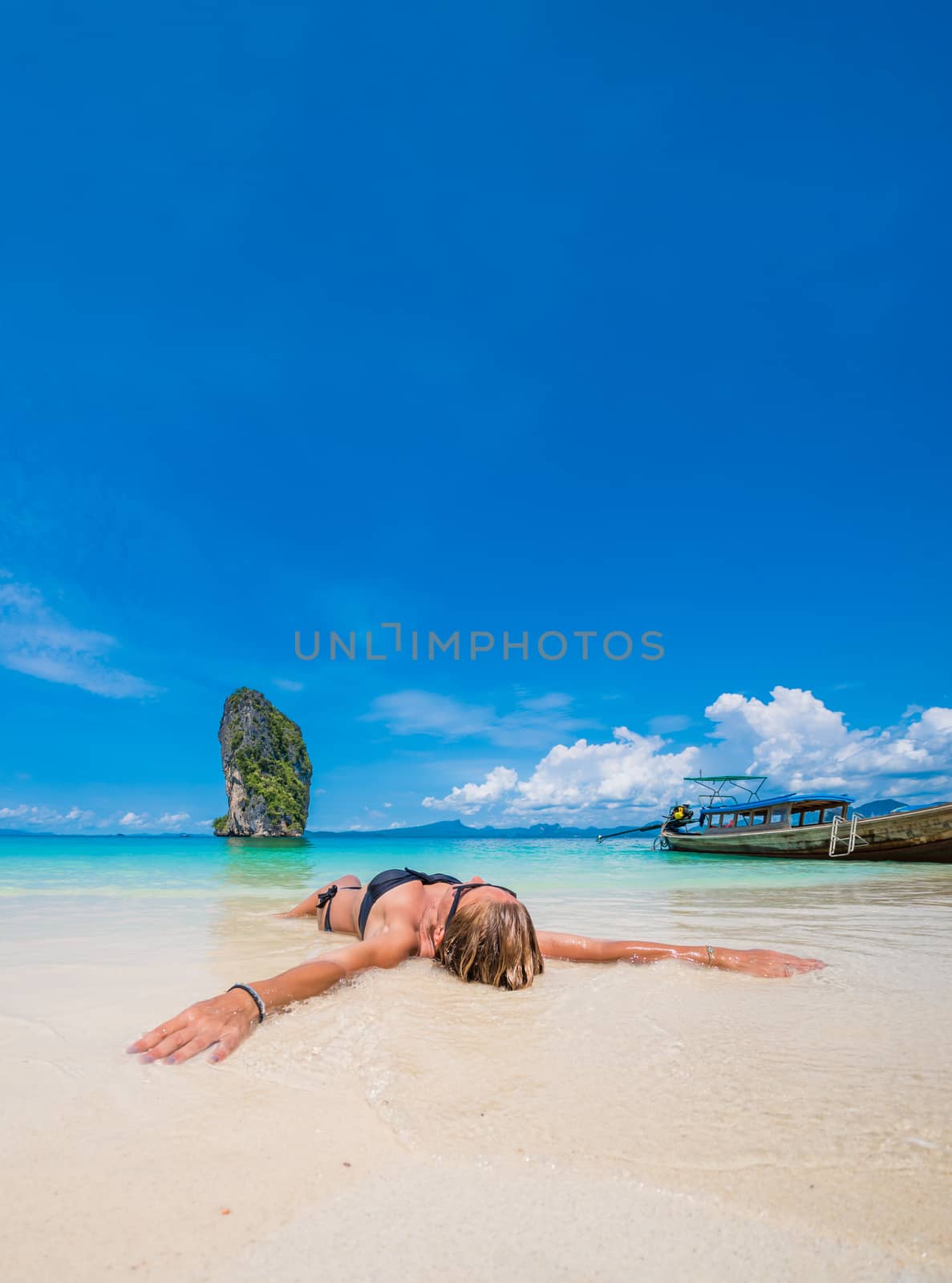 Cute woman relaxing on the beach by Netfalls