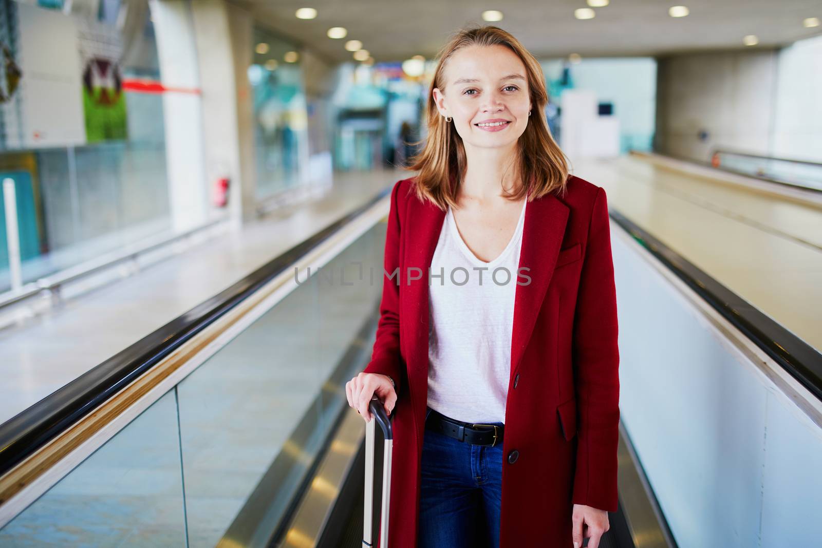 Young woman in international airport with luggage by jaspe