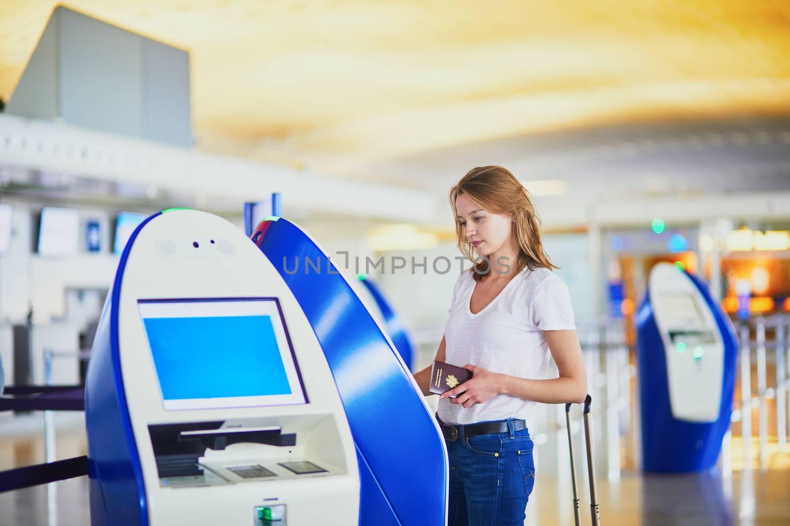 Young woman in international airport doing self check-in