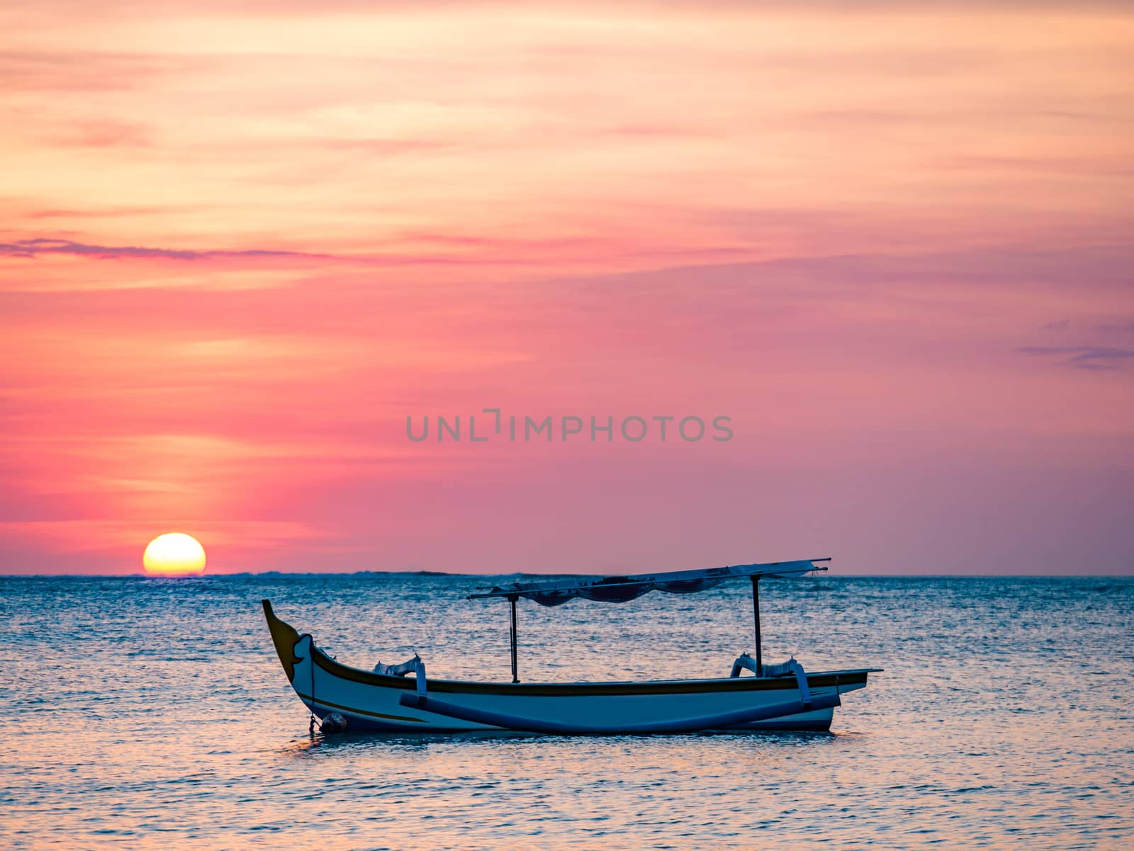 traditional Balinese ships Jukung close on Sanur beach at sunrise, Bali, Indonesia