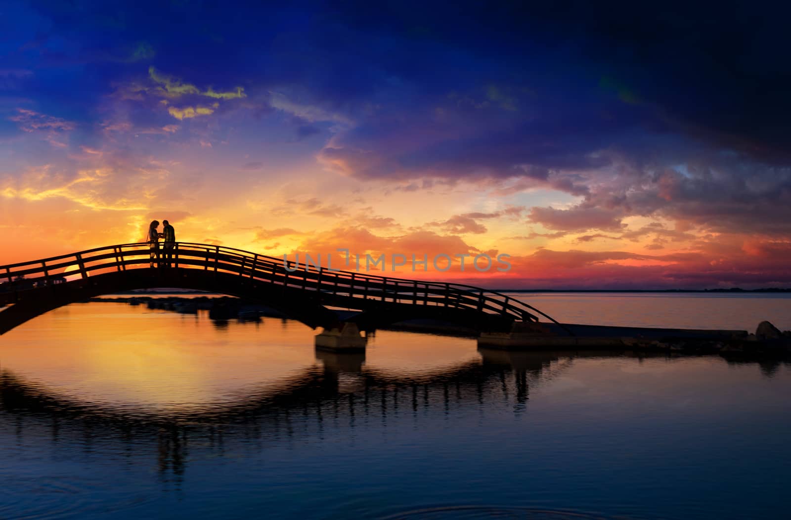 Couple enjoying the romantic sunset on the Lefkas town bridge by Netfalls