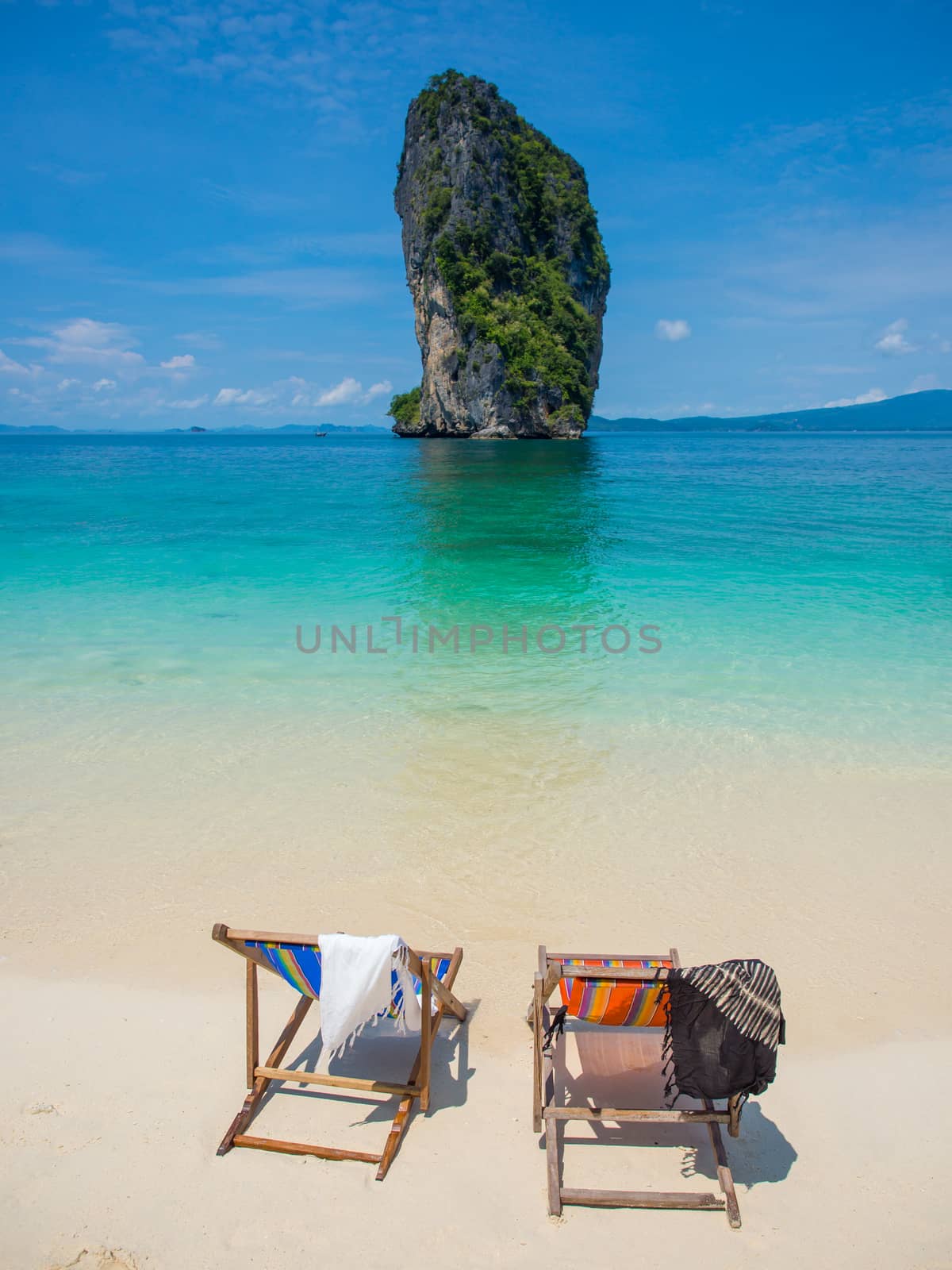 Empty chair on the beautiful beach under the clear blue sky  in Thailand