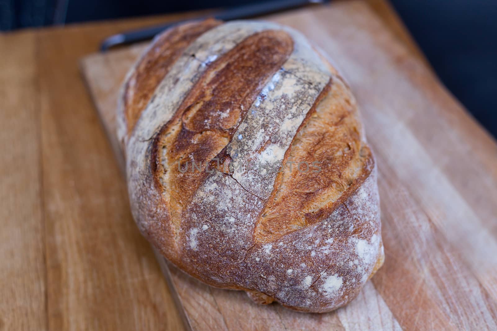Fresh bread loaf on a chopping board by magicbones