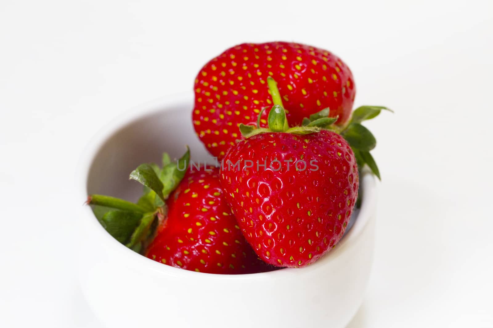 A bowl of strawberries on a white background