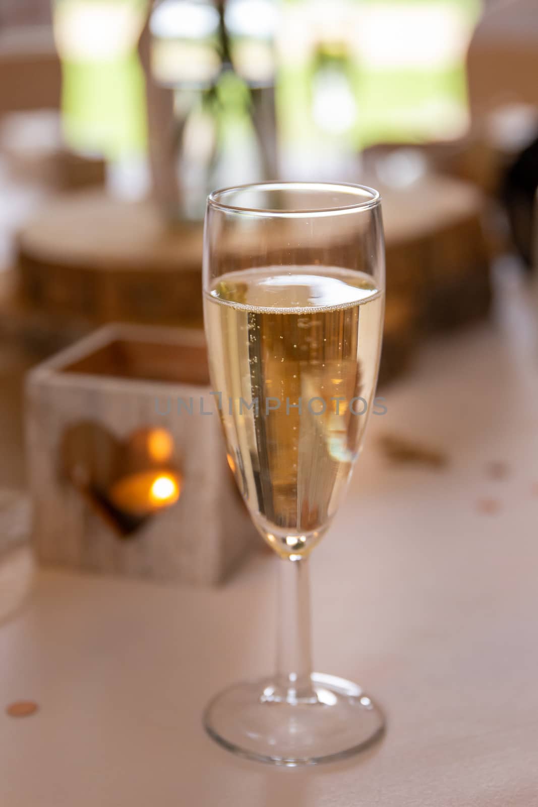 Love concept.  Champagne glass with heart shaped candle holder in a wedding setting