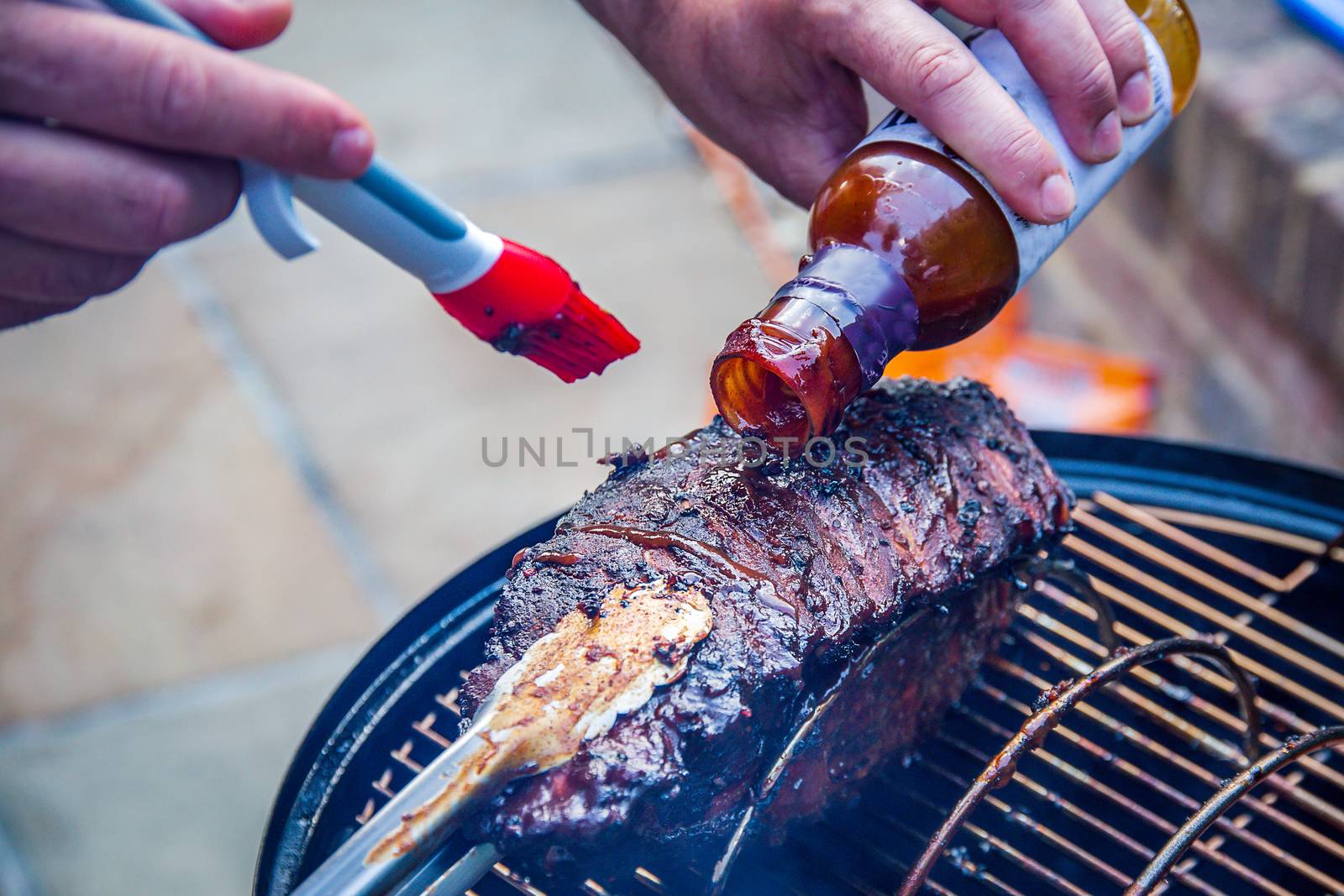 Cooking marinated baby back ribs on an outdoor barbecue