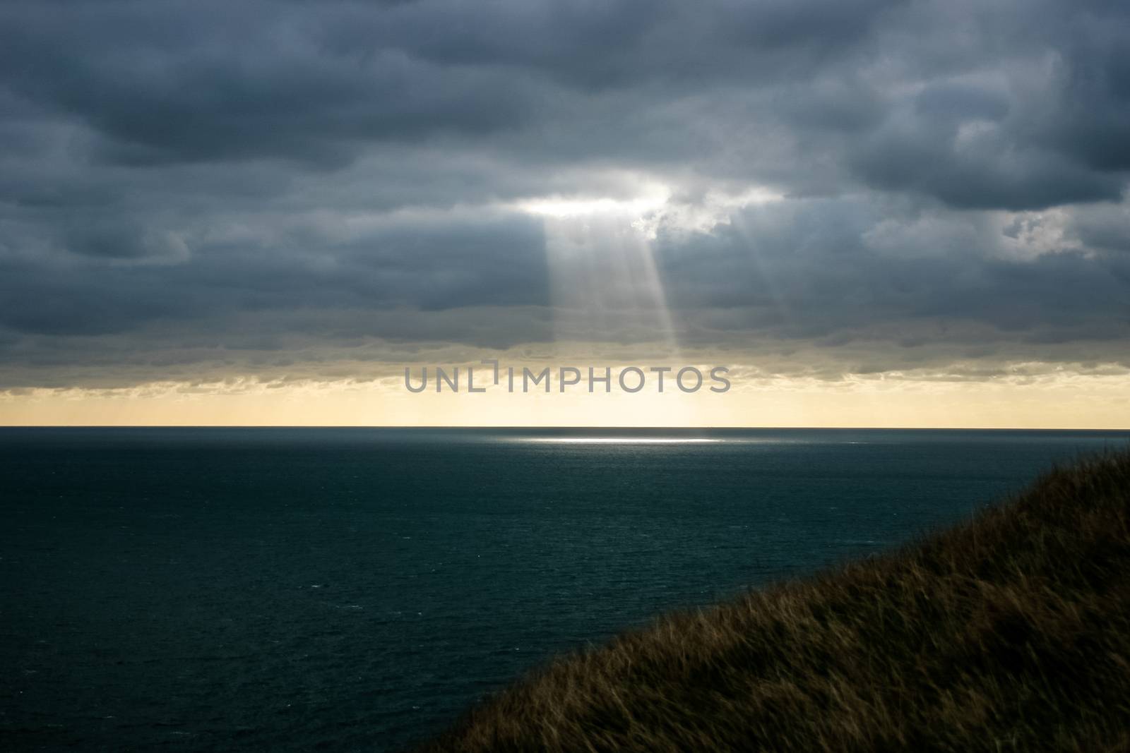 A shaft of light breaking through the dark clouds.  Provides imagery of hope, faith, religion