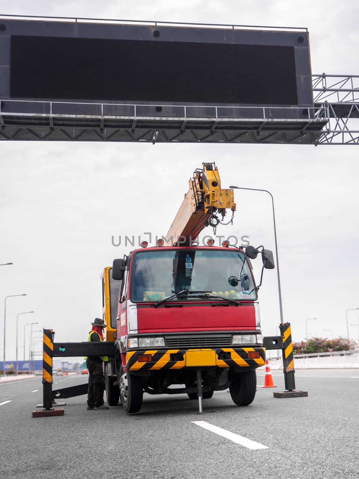 Construction site crane is lifting a led signboard for advertise by shutterbird