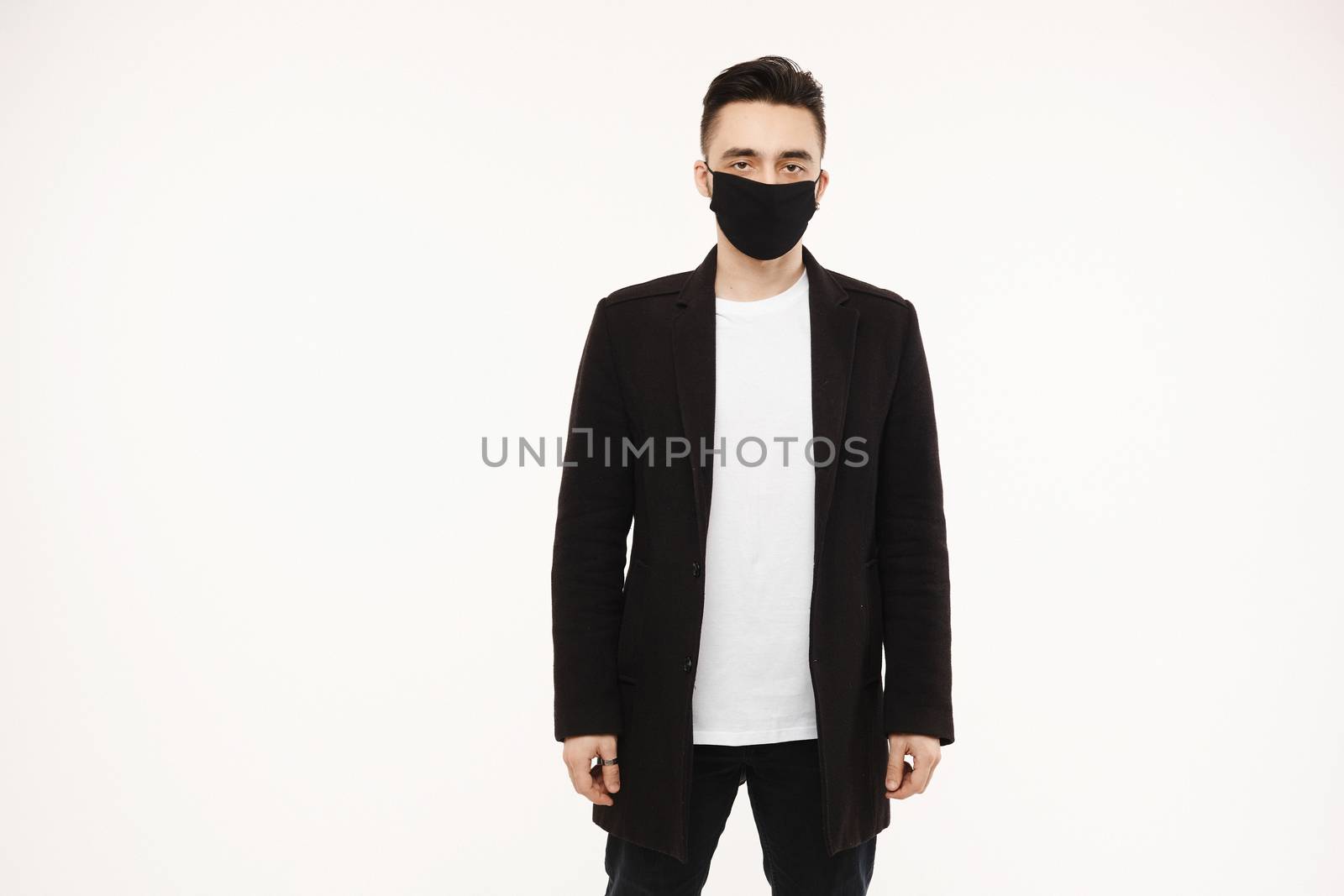 Handsome young man in black protective mask isolated on white background. Healthy lifestyle concept. Seasonal illness, and seasonal flu concept. Men wearing medical mask to prevent infection, airborne respiratory illness such as flu, 2019-nCoV.