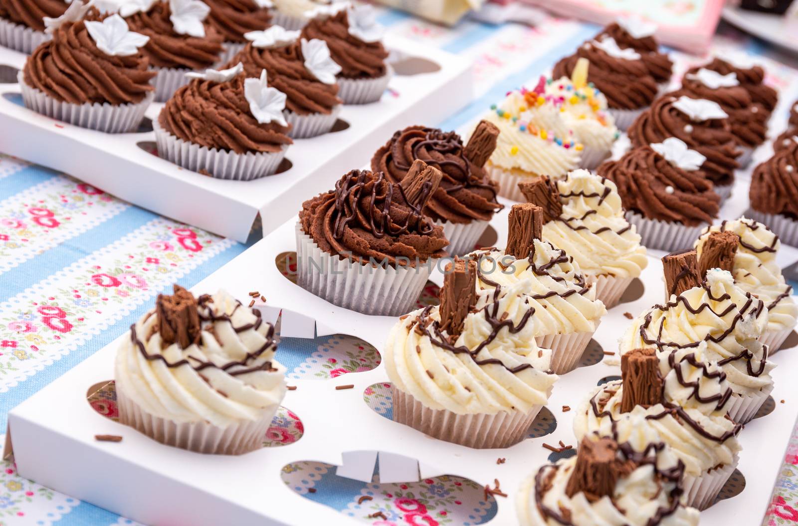 An assortment of homemade chocolate and vanilla cupcakes with a chocolate flake