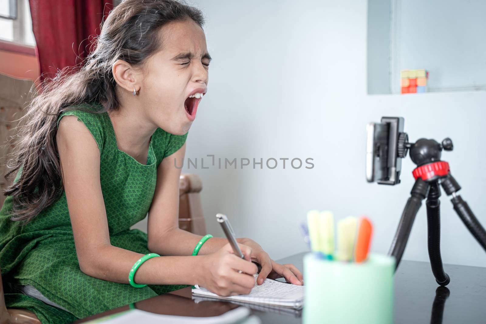 Girl shouting, screaming in front of mobilephone during e-learning or online class at home - concept of problem, stress, anxiety for students or kids in distance learning. by lakshmiprasad.maski@gmai.com