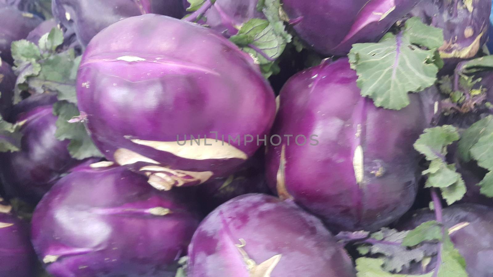 Fruits background: Purple fresh kohlrabi turnip in supermarket for sale by Photochowk