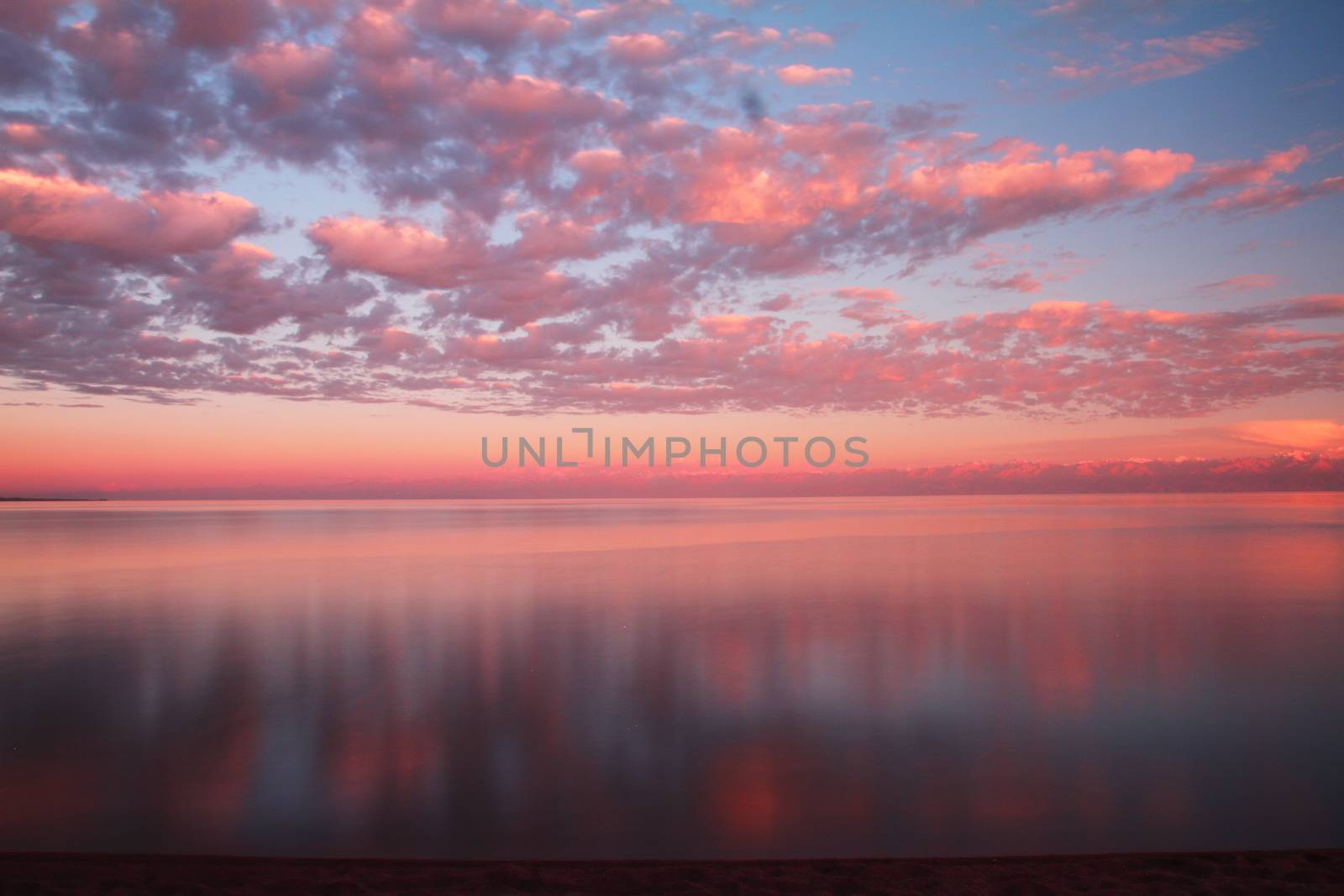 Clouds reflected on the water during sunset by selinsmo