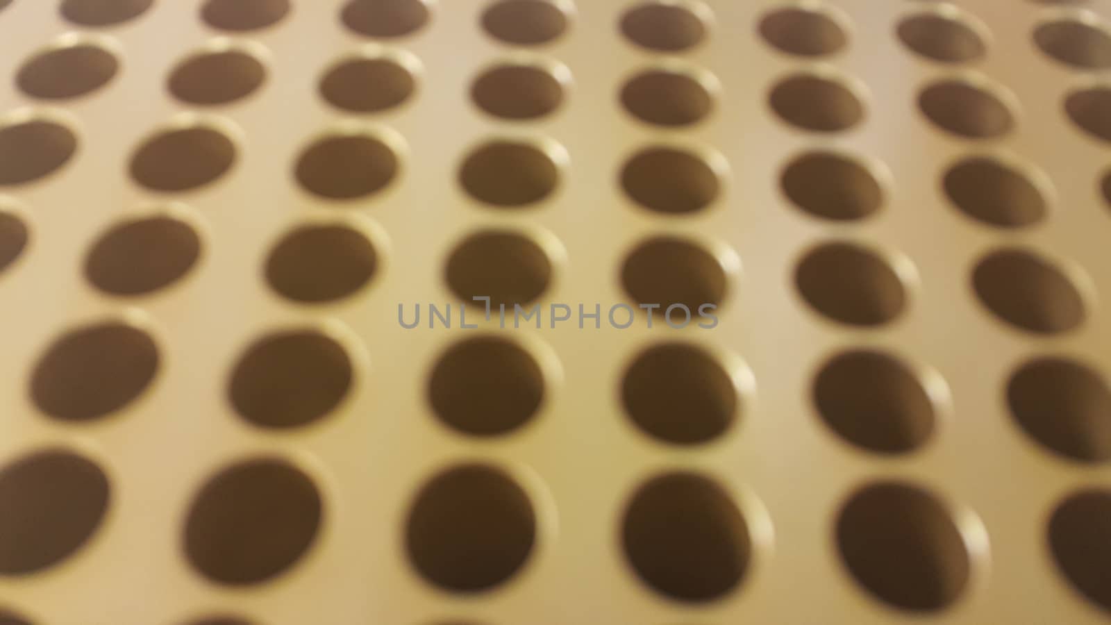 Close up view of holes in golden micro pipette box in research laboratory by Photochowk