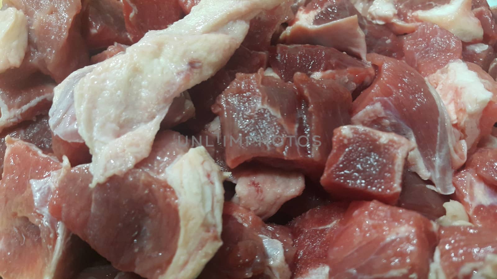 Close up view of fresh finely chopped meat cubes. Red meat small steaks with whitish meat fat.