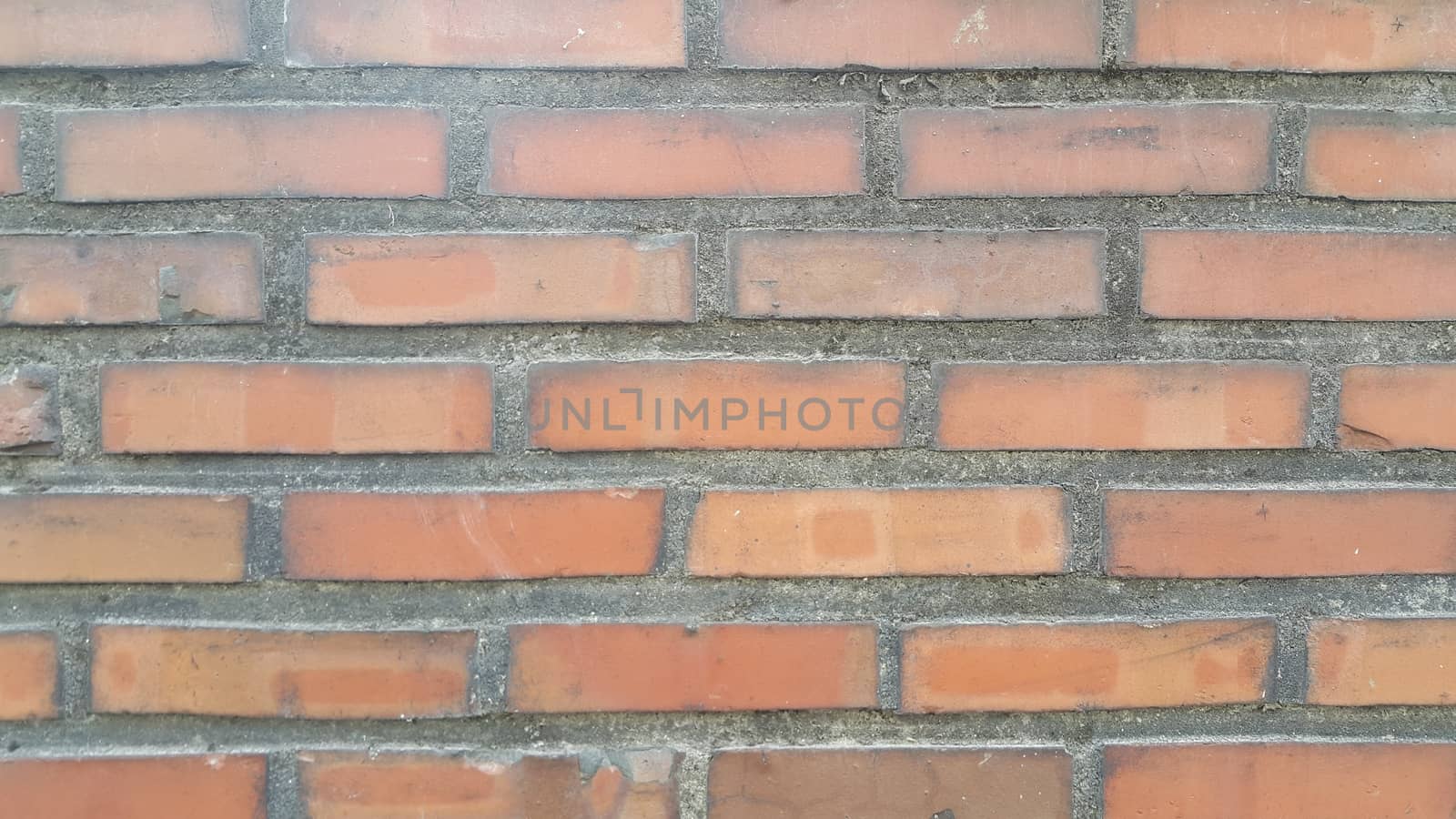 Closeup texture of red brick wall. A background of a weathered old exterior brick wall in the sunshine.