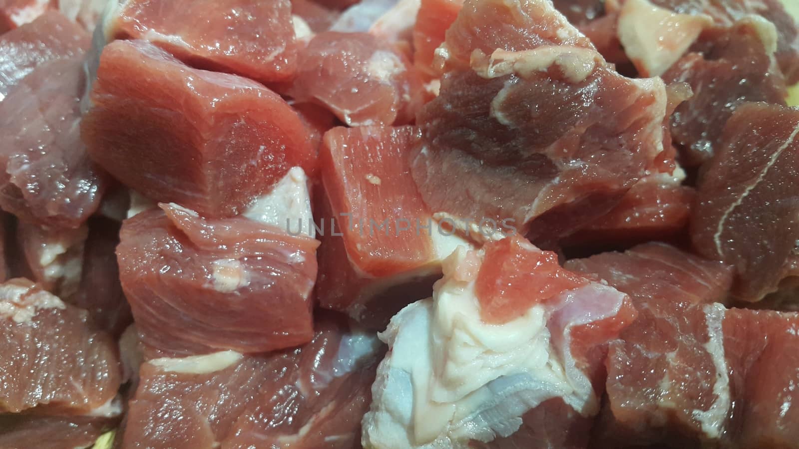 Close up view of fresh finely chopped meat cubes. Red meat small steaks with whitish meat fat.