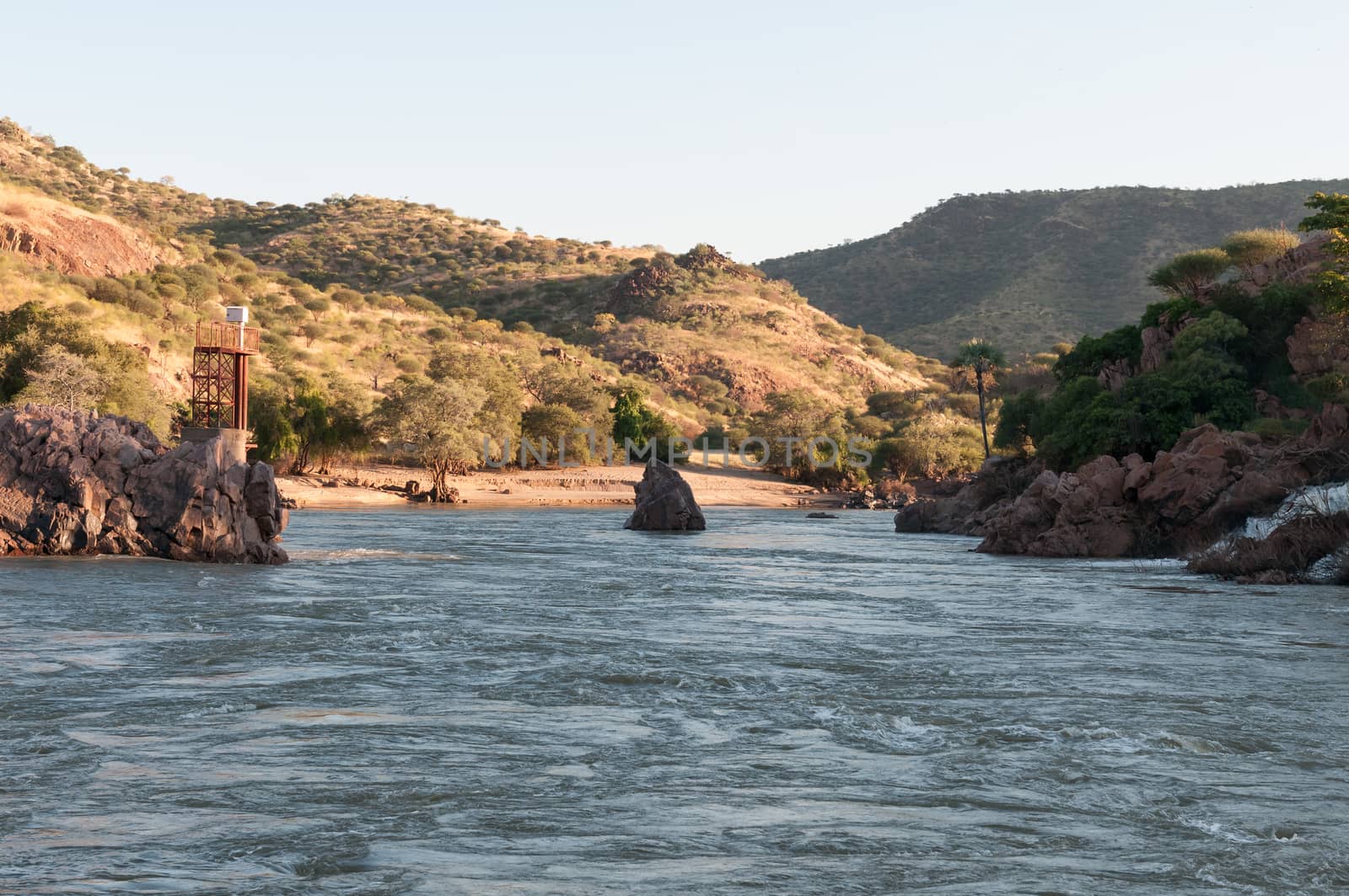 The Kunene River below the Epupa waterfalls. A flood level monitor tower is visible
