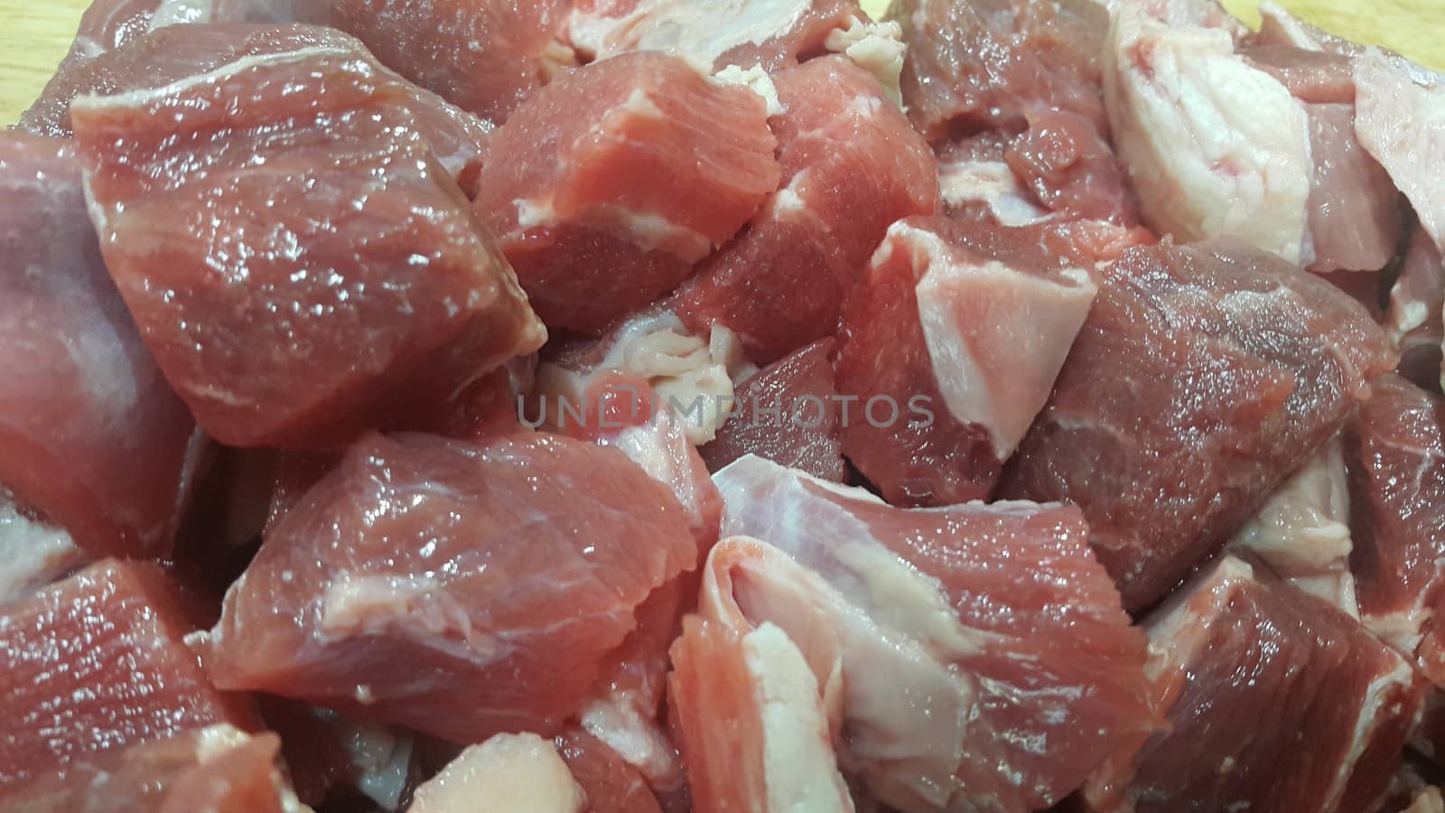 Close up view of fresh finely chopped meat cubes. Red meat small steaks with whitish meat fat.