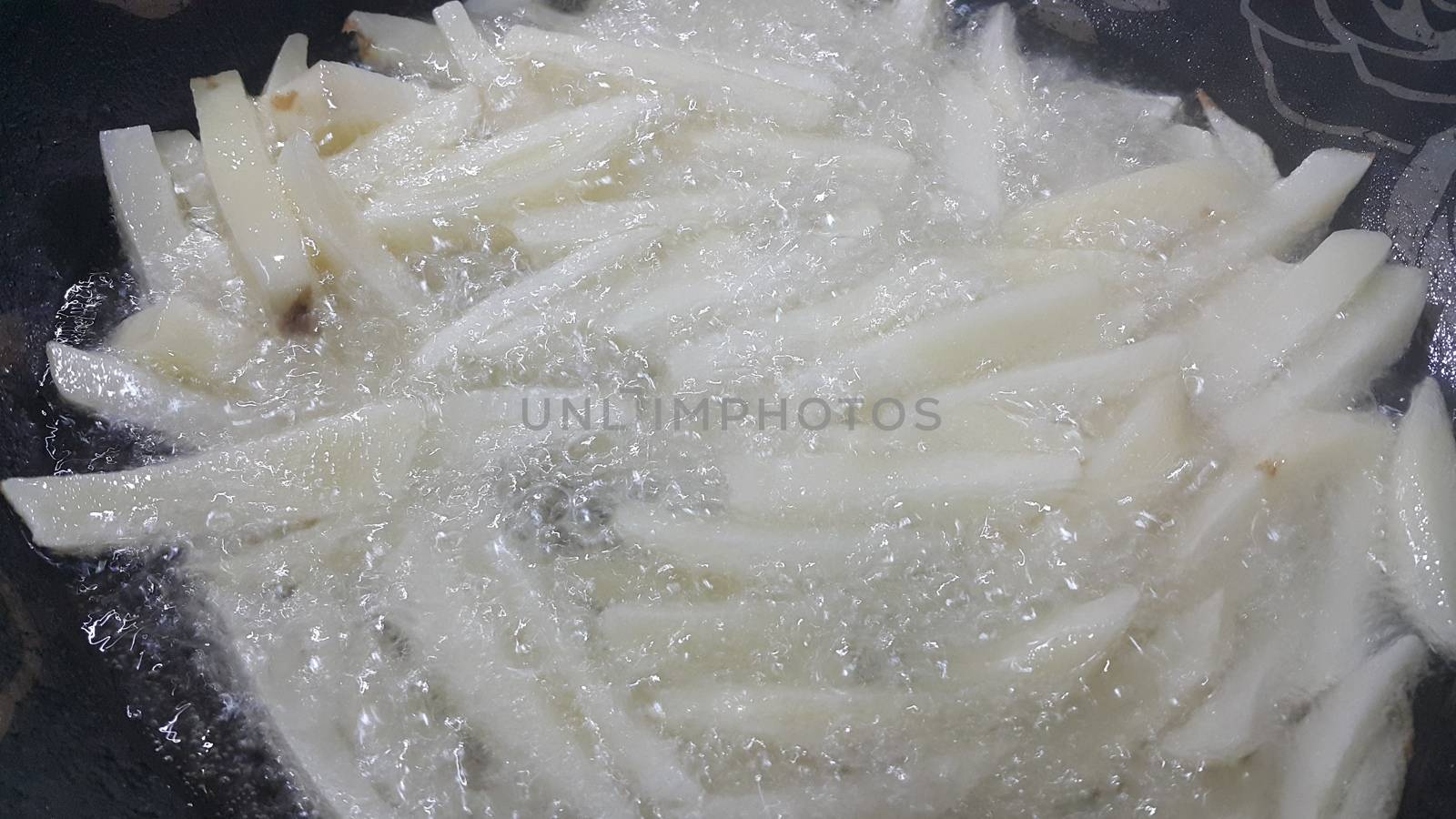 Closeup view of uncooked potato french fries or potato sticks by Photochowk