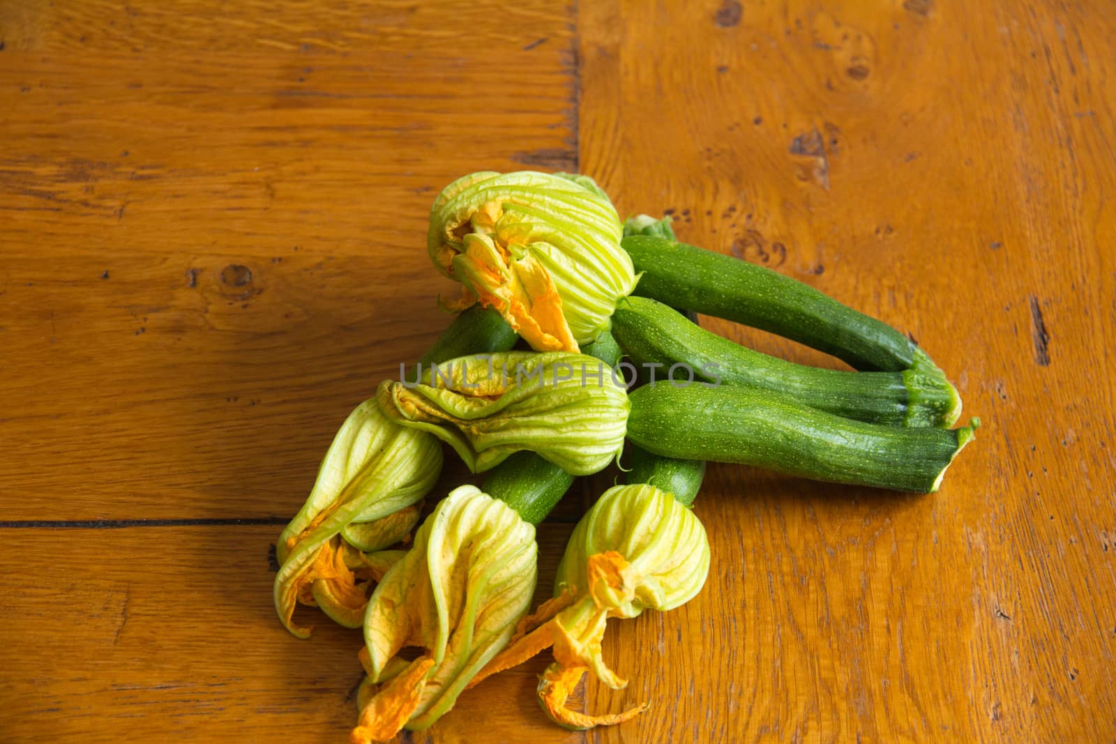 Arrangement of courgettes (zucchinis) on a wooden kitchen table