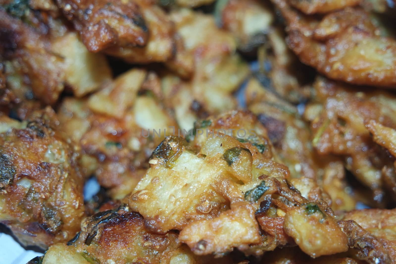 close-up view with selective focus of crispy basin pakora/pakoda or patties are popular indian or pakistani street food snack, served with green salad and sauce. Selective focus of