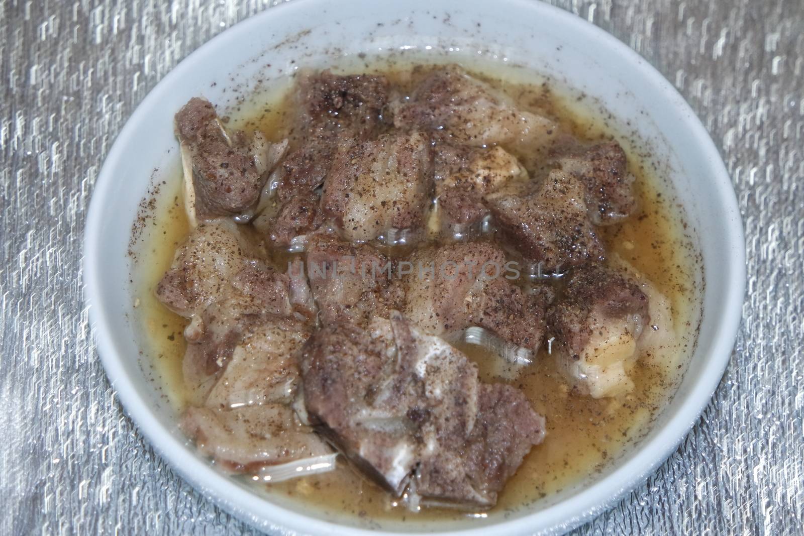 Top view of siri paaye or paya dish garnished with diced ginger, long coriander and black pepper. This dish is popular in Pakistan and Bangladesh