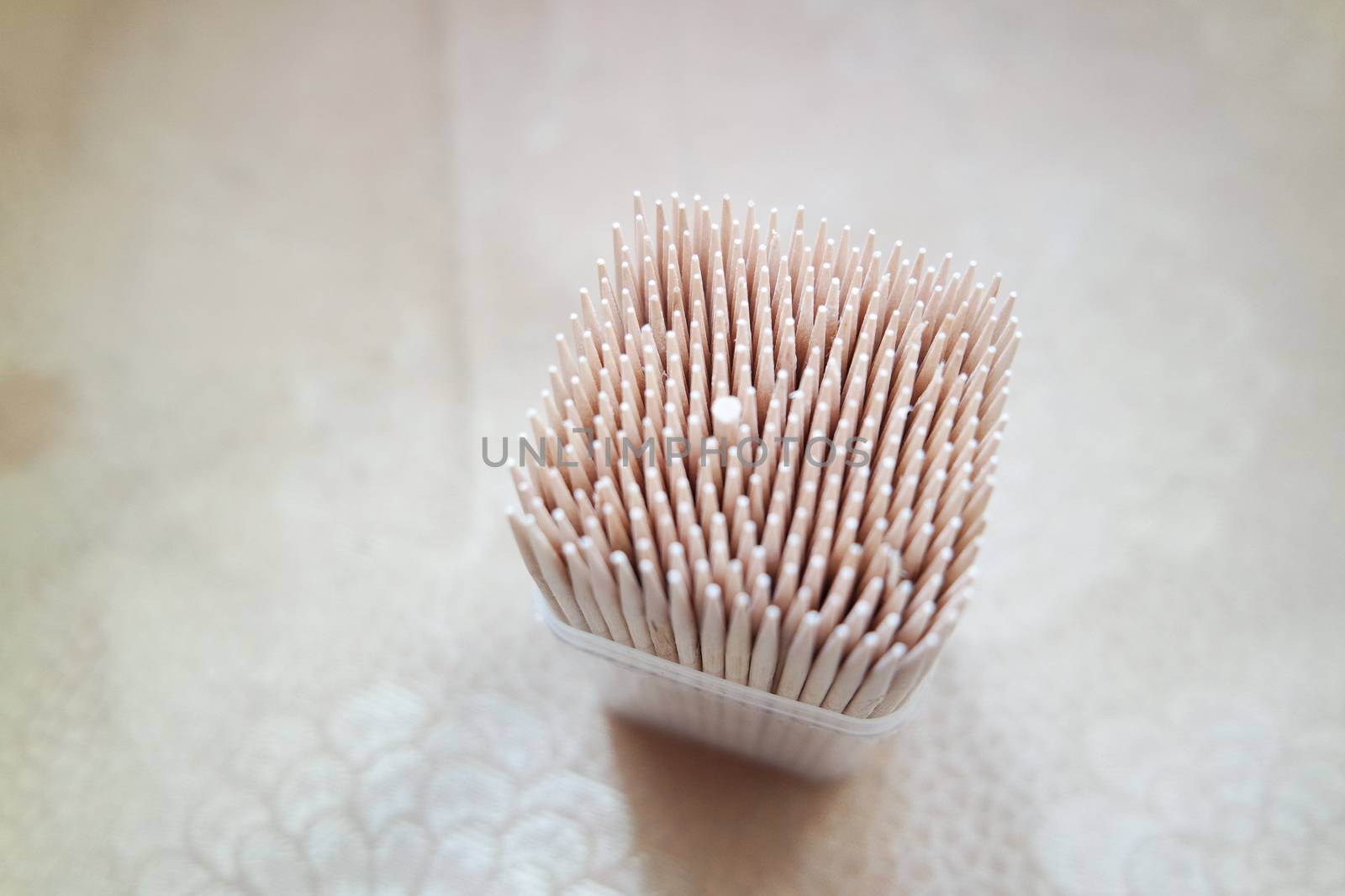 High angle top view of wood needles or wooden tooth picks arranged in a white plastic box container