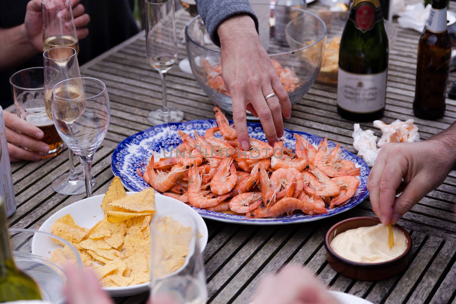 Friends aharing a plate of prawns at a social gathering