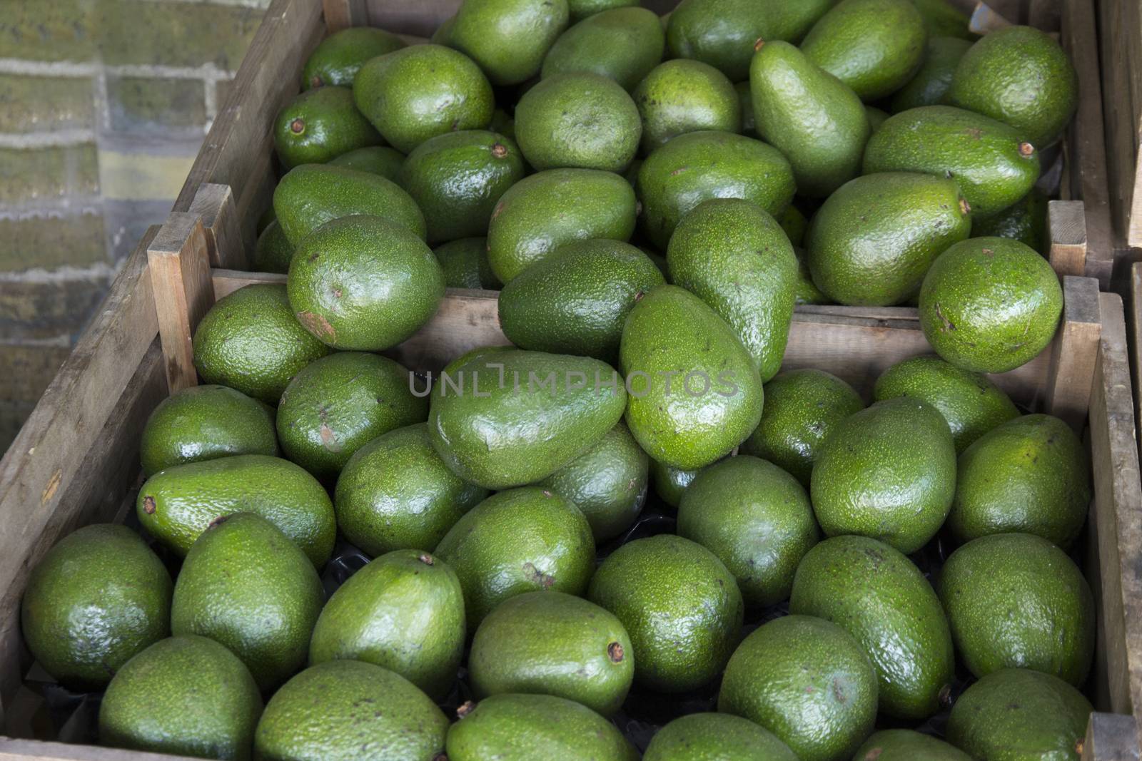 Avocados for sale in wooden boxes on a market stall