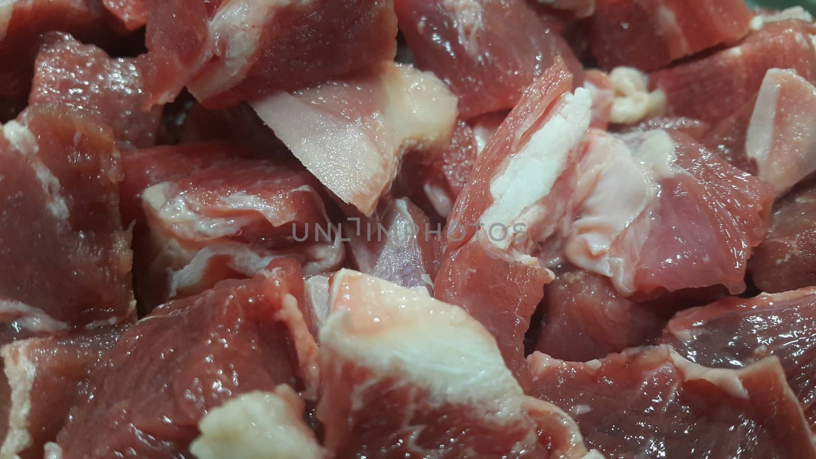 Close up view of fresh finely chopped meat cubes. Red meat small steaks with whitish meat fat.