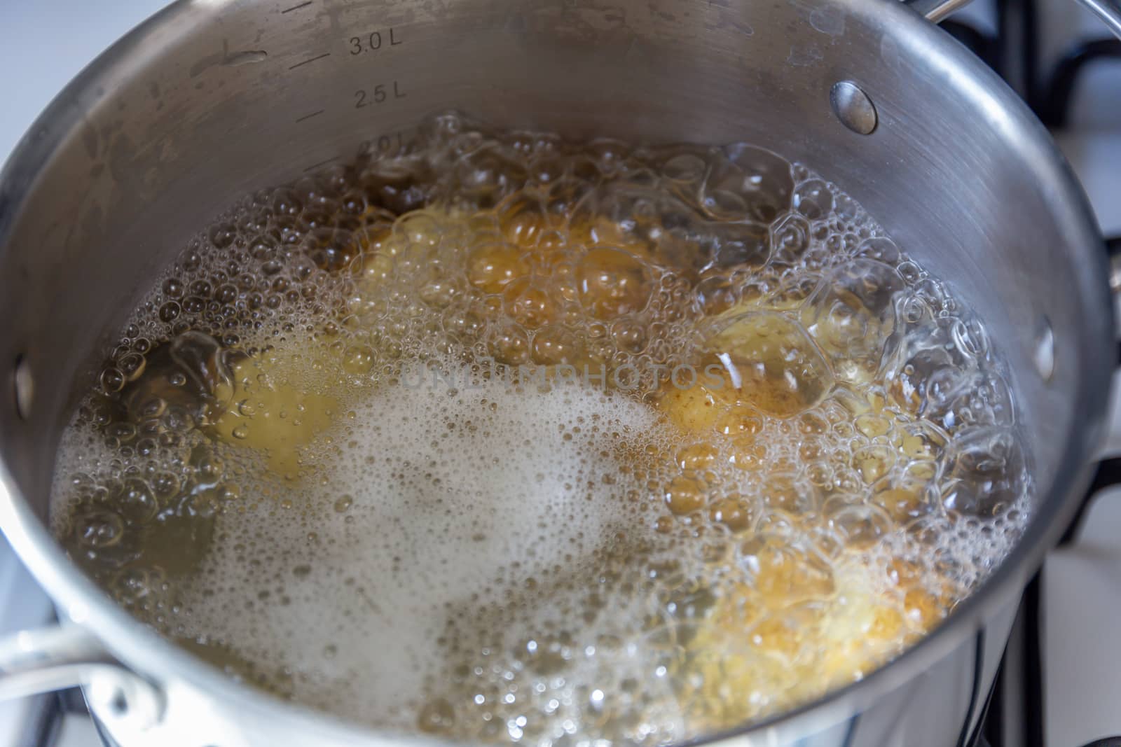 Pan of potatoes cooking in boiling water by magicbones