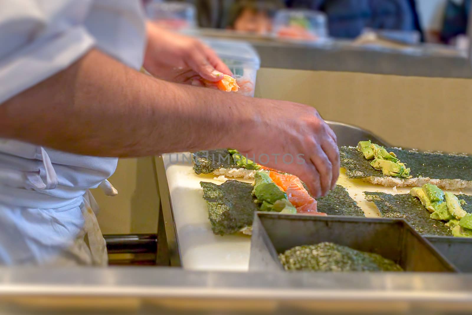 A sushi chef preparing Uramaki with avocado and salmon