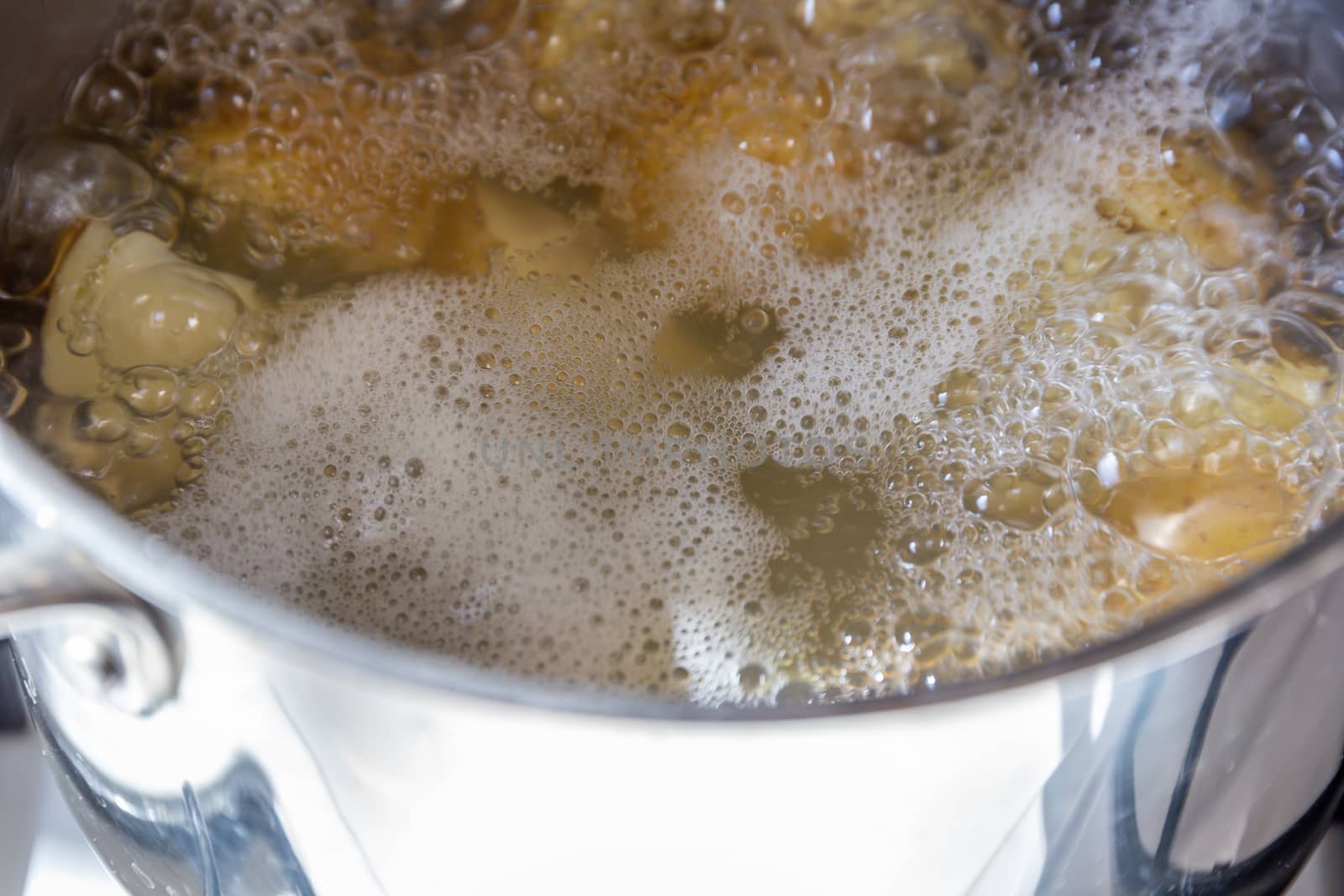 Pan of potatoes cooking in boiling water by magicbones