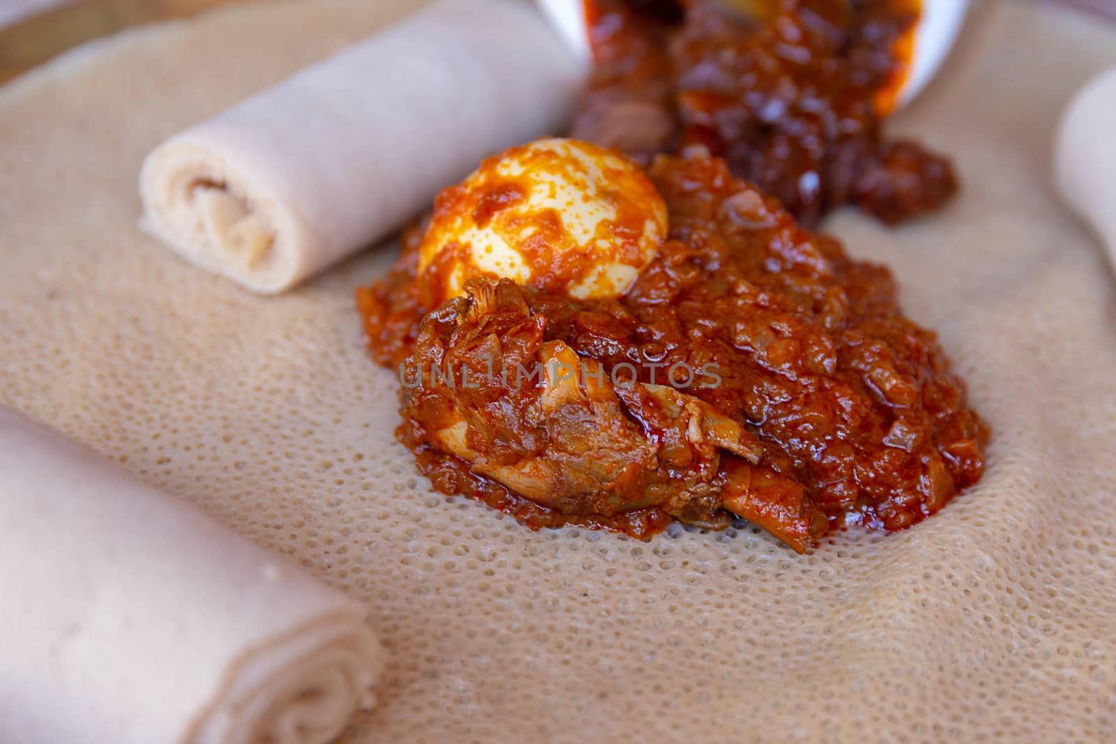 Injera served with Chicken and egg Doro Wat.  Injera is a sourdough flatbread made from teff flour.  It is the national dish of Ethiopia, Eritrea, Somalia and Djibouti