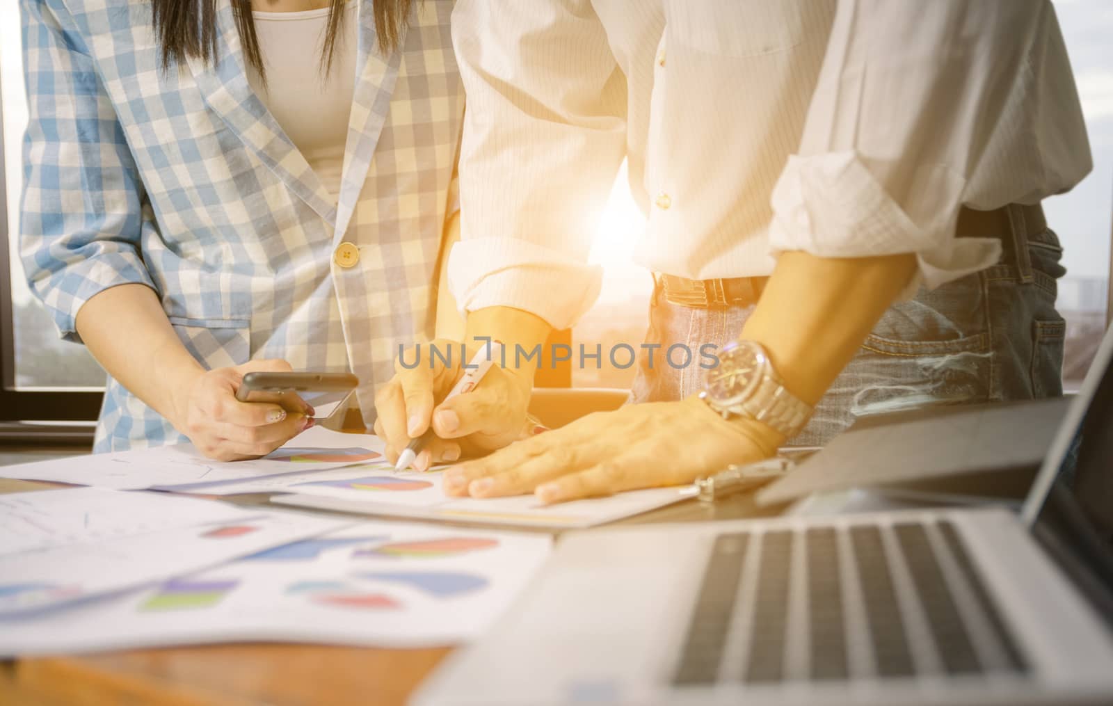 Working business team graph analysis on the desk city background evening sun