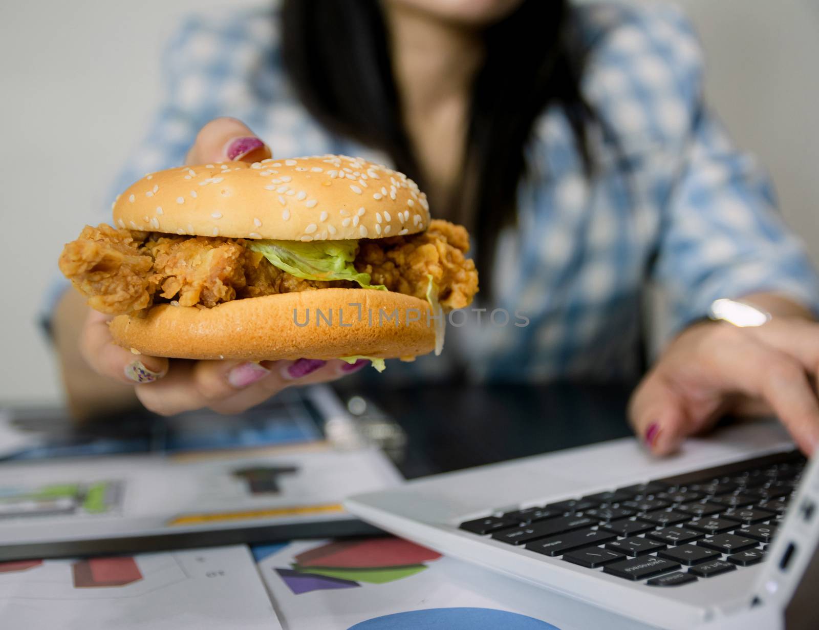 Women work and eat hamburgers to eat lunch in office