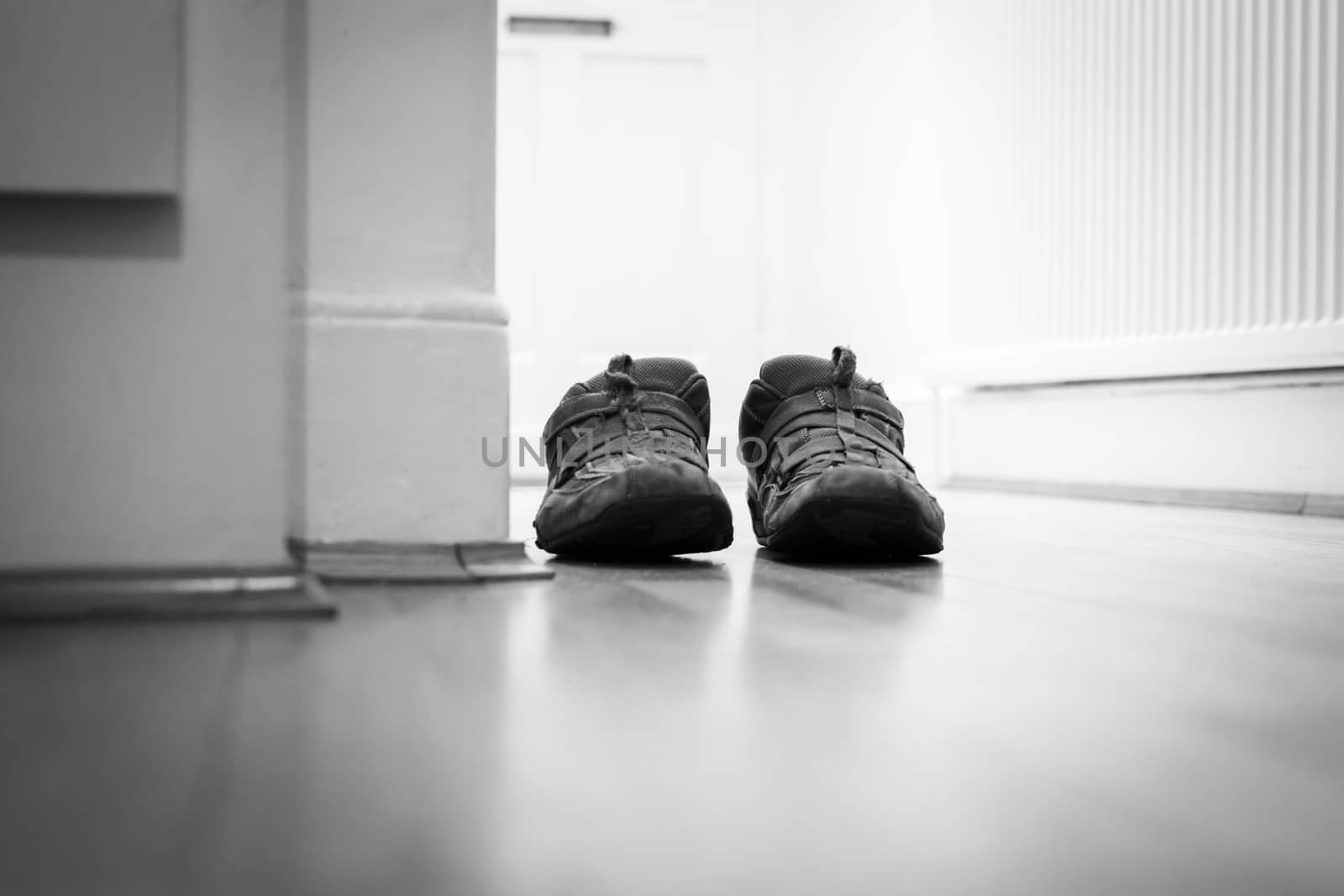 Pair of casual shoes in a domestic hallway