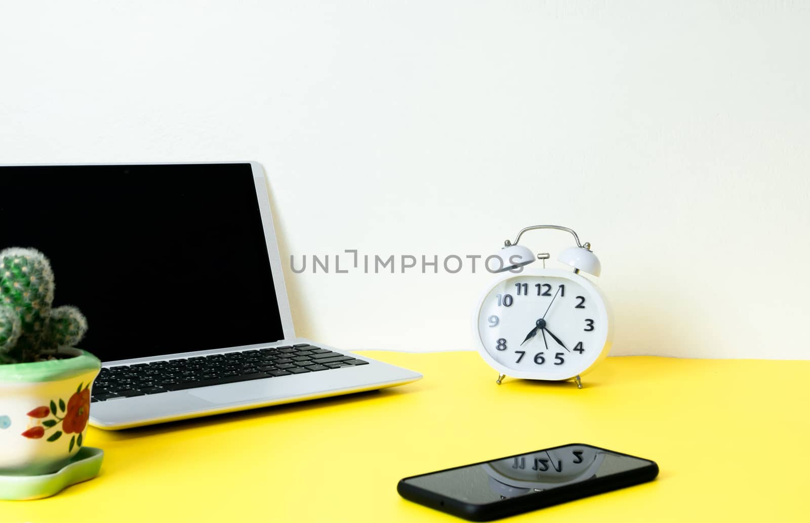 Laptop placed on a yellow table background of business working place with cup coffee, Empty workspace